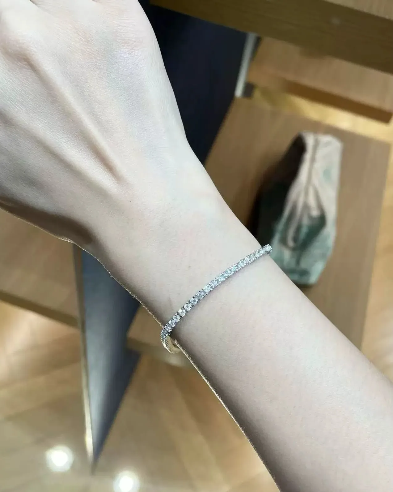 Moissanite tennis bracelet worn on a wrist in daylight